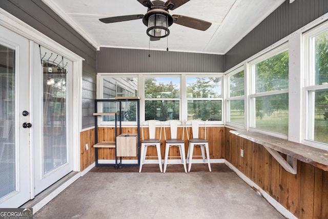 unfurnished sunroom with ceiling fan