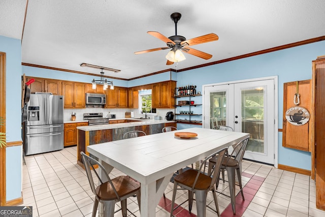 kitchen with light tile patterned floors, stainless steel appliances, hanging light fixtures, light countertops, and brown cabinetry