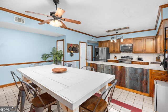 kitchen featuring stainless steel appliances, visible vents, decorative backsplash, brown cabinetry, and a sink