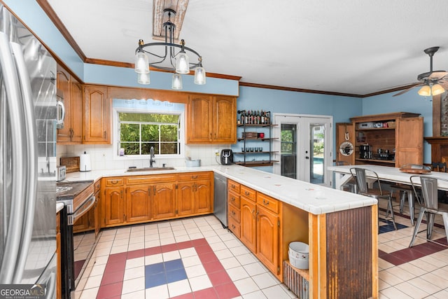 kitchen with pendant lighting, brown cabinets, open shelves, appliances with stainless steel finishes, and a sink