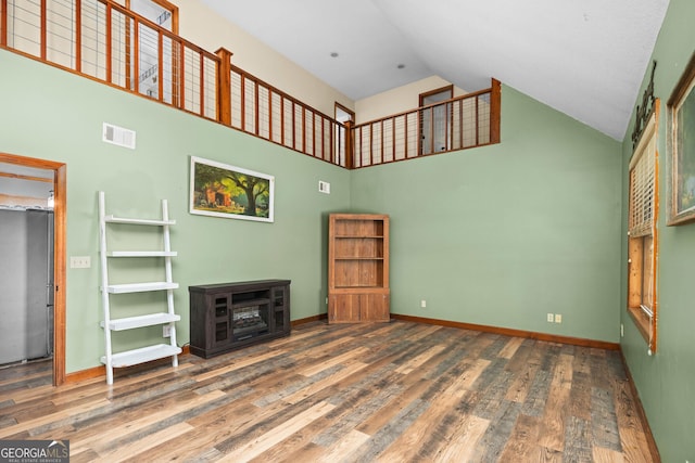 unfurnished living room featuring high vaulted ceiling, baseboards, visible vents, and dark wood finished floors