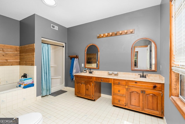 full bathroom with double vanity, baseboards, visible vents, a bath, and a sink