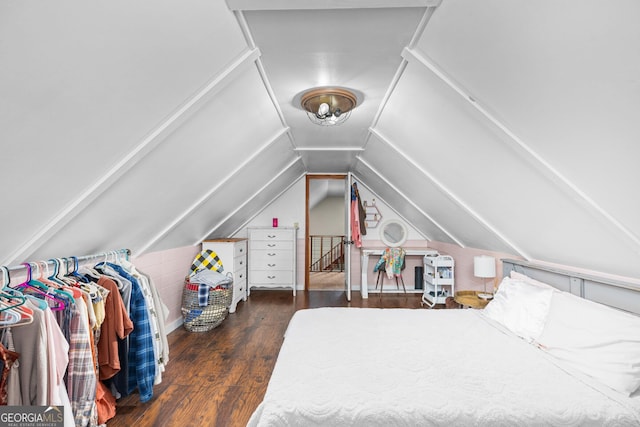 bedroom featuring vaulted ceiling and dark wood-style flooring