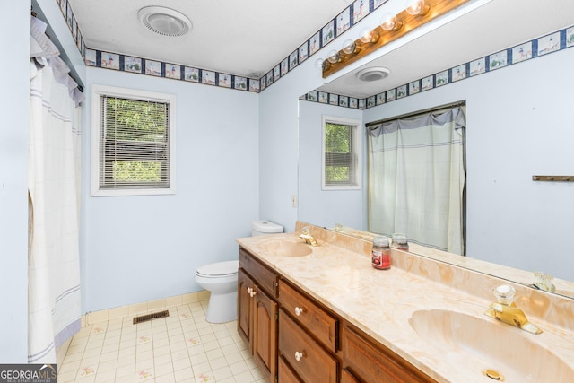 bathroom with toilet, double vanity, a sink, and visible vents