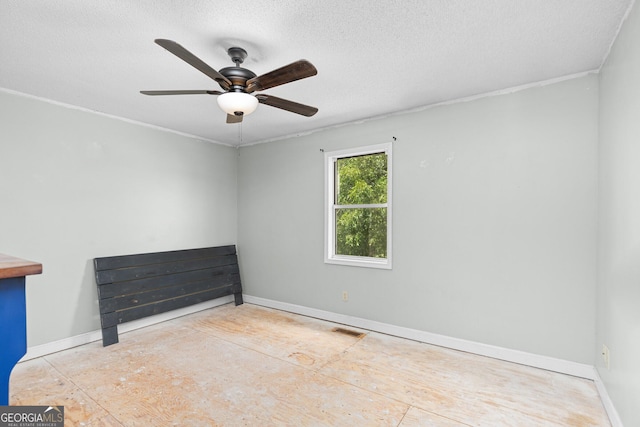 unfurnished room featuring a ceiling fan, baseboards, visible vents, and a textured ceiling