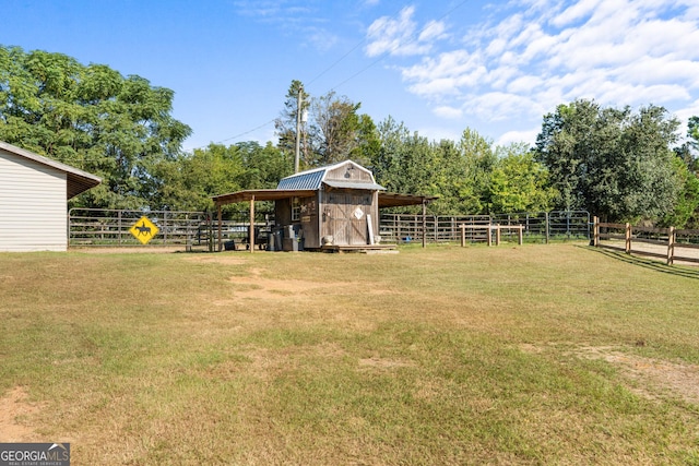 view of yard featuring an exterior structure, an outdoor structure, and a rural view