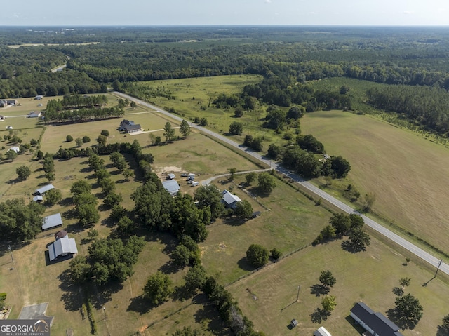 drone / aerial view featuring a rural view and a wooded view