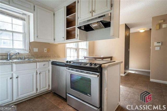 kitchen with stainless steel appliances, light countertops, white cabinetry, a sink, and under cabinet range hood