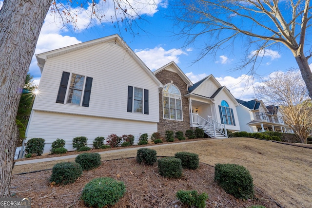 view of front of house with stone siding and a front lawn