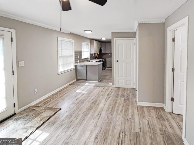 empty room featuring plenty of natural light, baseboards, ceiling fan, and wood finished floors