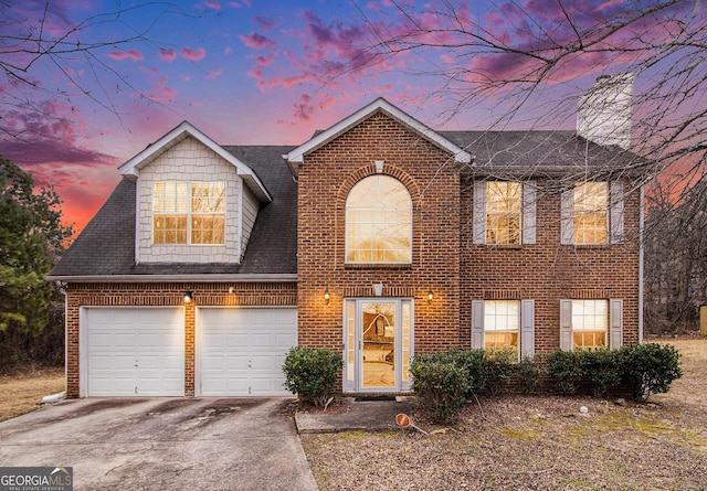 view of front of home with a shingled roof, concrete driveway, and brick siding