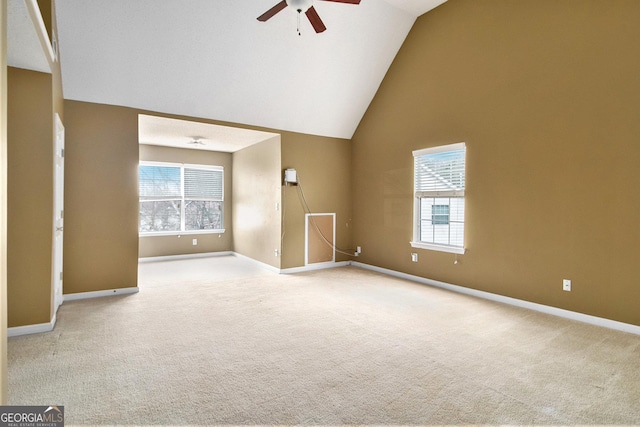 unfurnished room featuring high vaulted ceiling, a wealth of natural light, and carpet