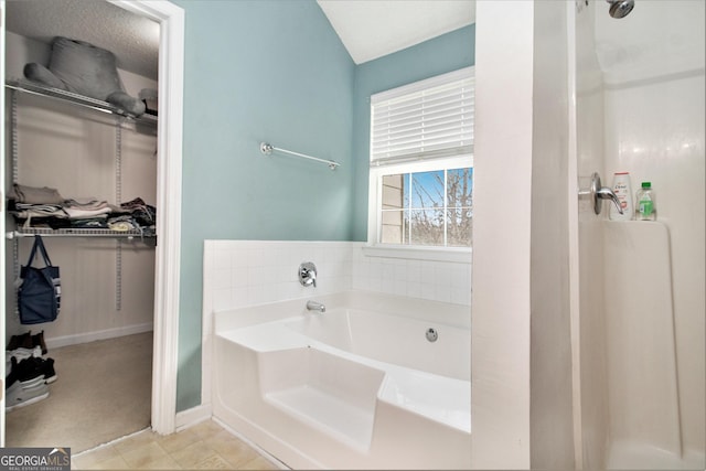 full bath with a garden tub and a walk in closet