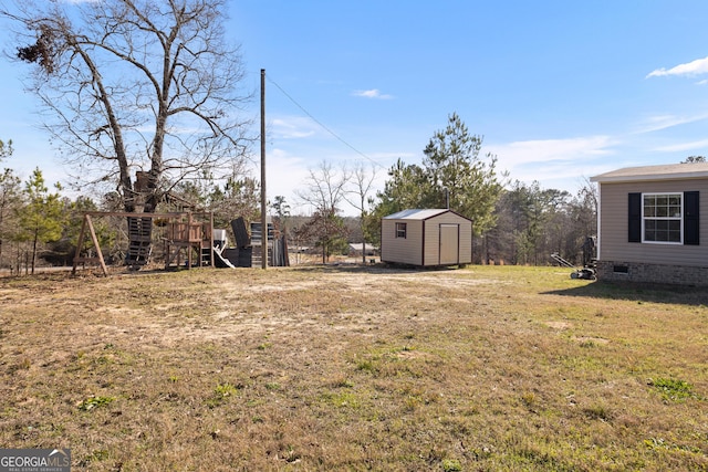 view of yard with a shed, a playground, and an outbuilding