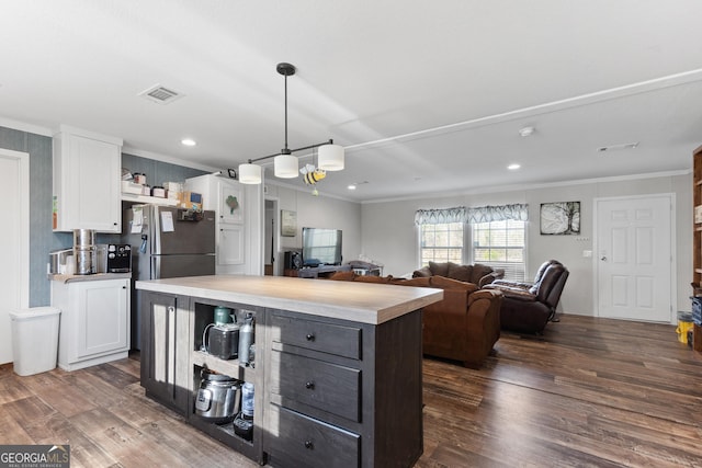 kitchen with a center island, light countertops, visible vents, open floor plan, and white cabinets