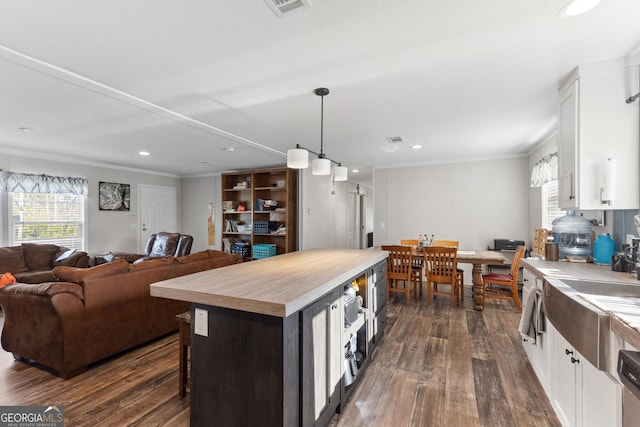 kitchen with a kitchen island, white cabinetry, light countertops, and dark wood finished floors