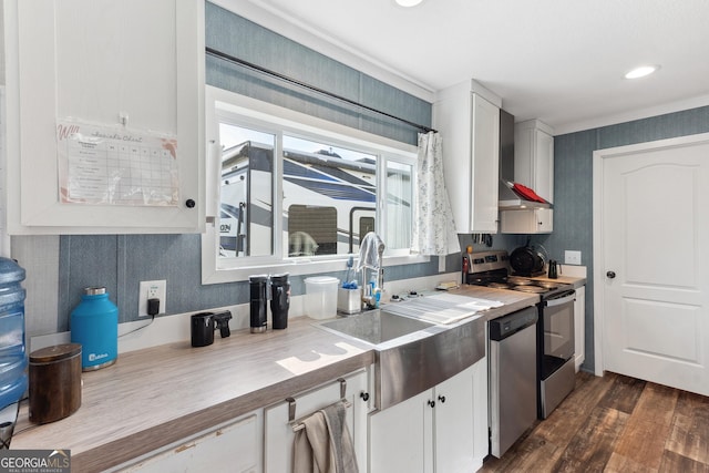 kitchen with butcher block countertops, appliances with stainless steel finishes, and white cabinets