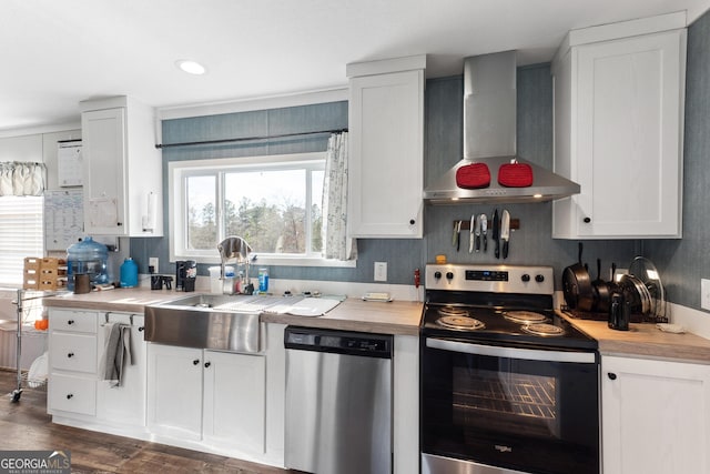 kitchen featuring electric stove, dark wood-type flooring, white cabinets, wall chimney range hood, and dishwasher