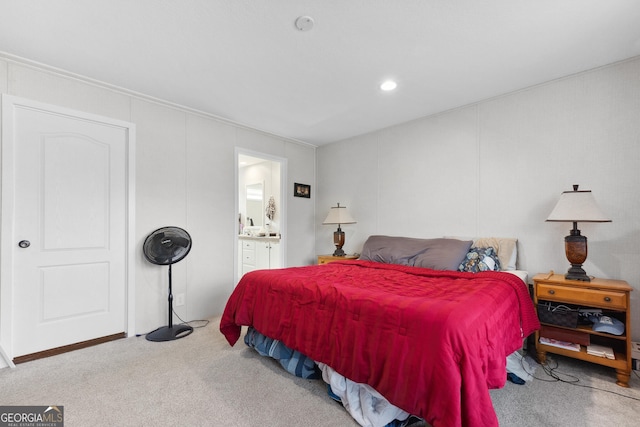 carpeted bedroom featuring ensuite bathroom and a decorative wall