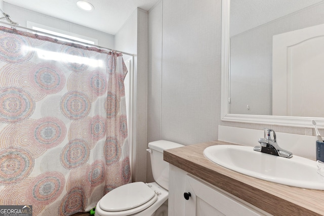 bathroom featuring toilet, vanity, and a shower with curtain