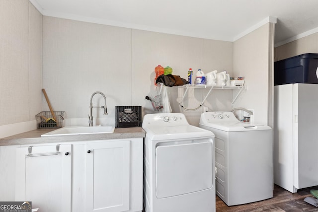 washroom featuring dark wood finished floors, cabinet space, ornamental molding, a sink, and independent washer and dryer