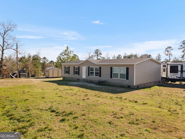 manufactured / mobile home featuring a storage shed, a front lawn, crawl space, and an outdoor structure