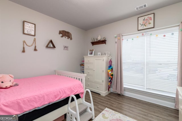 bedroom featuring baseboards, visible vents, and dark wood finished floors