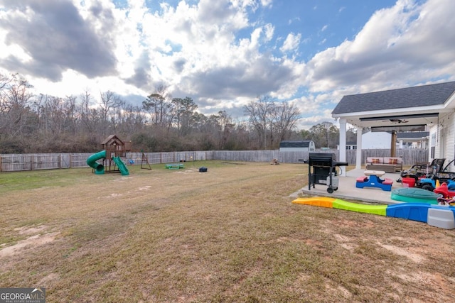 view of yard with a playground, a patio, a fenced backyard, and a storage unit