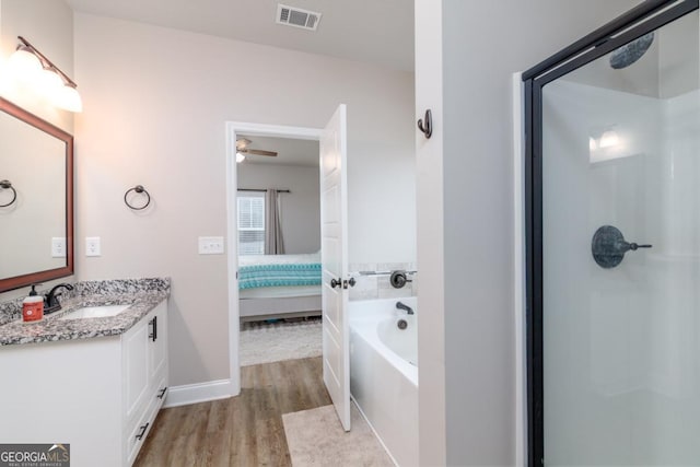 bathroom with ensuite bathroom, wood finished floors, vanity, visible vents, and a bath