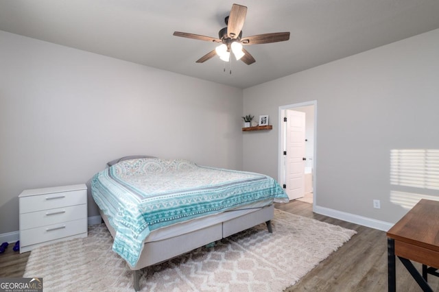 bedroom featuring wood finished floors, a ceiling fan, and baseboards