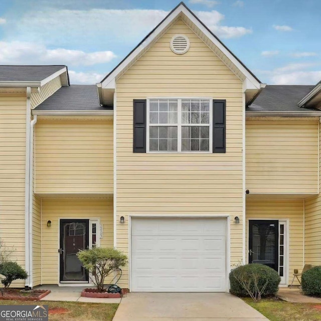 view of property with a garage and driveway