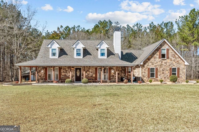 view of front of property featuring a front yard, covered porch, and roof with shingles