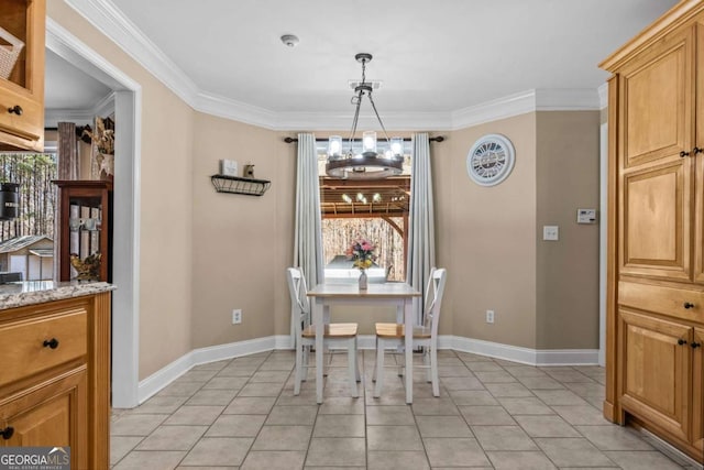 dining room with a chandelier, ornamental molding, baseboards, and light tile patterned floors