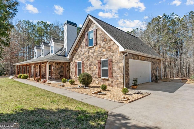 view of side of property featuring a porch, an attached garage, driveway, a lawn, and a chimney