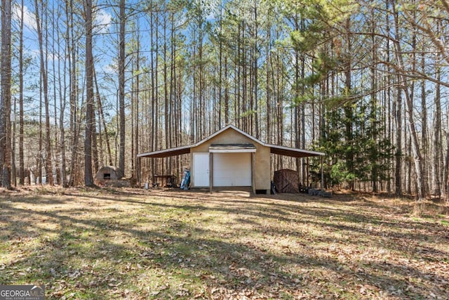 garage with driveway and a detached garage