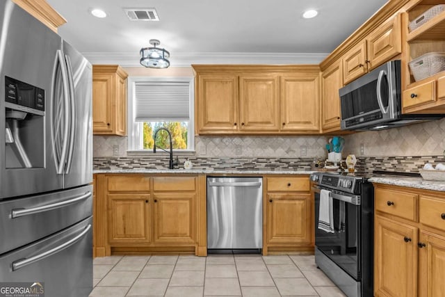 kitchen with light tile patterned floors, visible vents, appliances with stainless steel finishes, light stone countertops, and tasteful backsplash