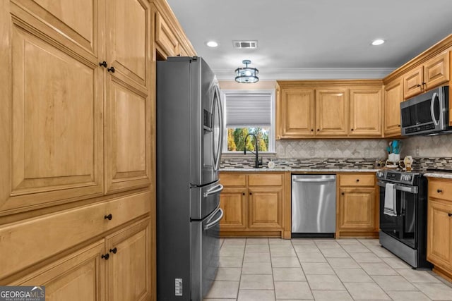 kitchen featuring appliances with stainless steel finishes, visible vents, a sink, and backsplash