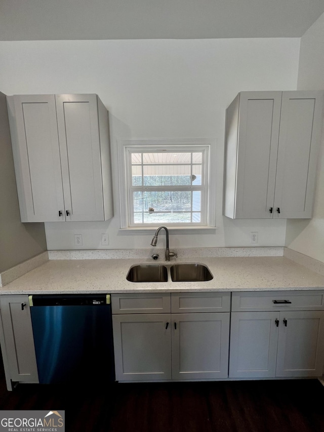 kitchen with dishwasher, light stone counters, gray cabinets, and a sink