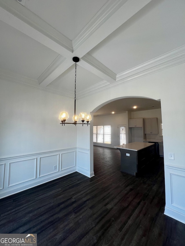 unfurnished dining area featuring arched walkways, coffered ceiling, dark wood-style floors, beamed ceiling, and an inviting chandelier