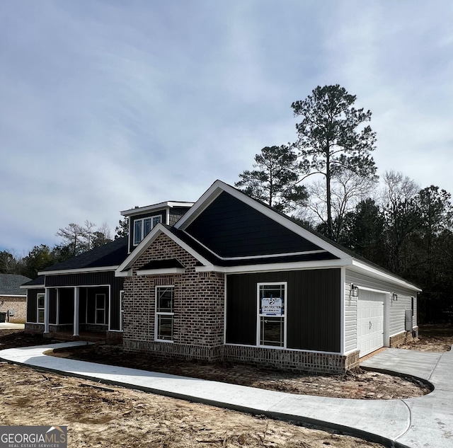 view of front of property with a garage, driveway, and brick siding