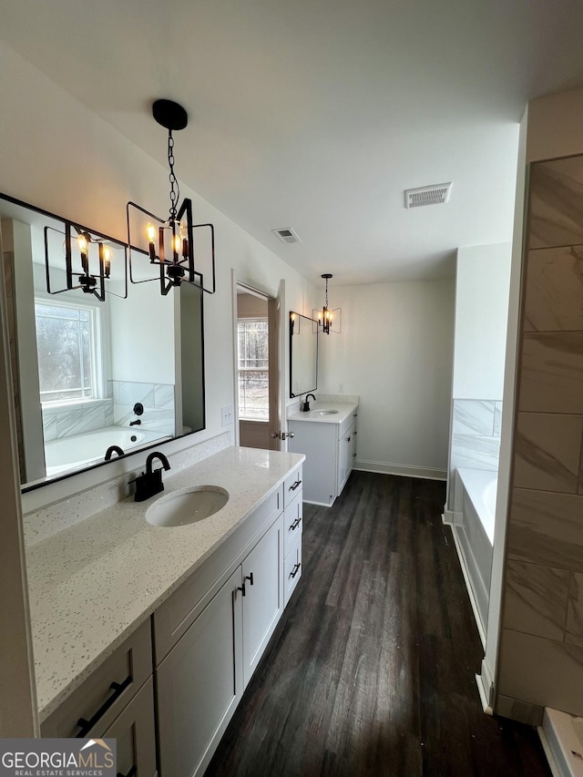 full bathroom with visible vents, two vanities, and a sink