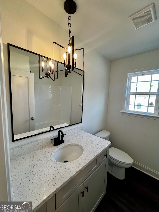 full bathroom featuring toilet, vanity, visible vents, baseboards, and walk in shower