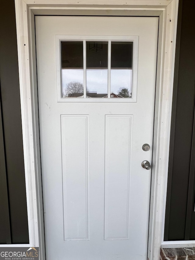 property entrance featuring board and batten siding