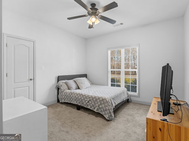 bedroom featuring baseboards, visible vents, a ceiling fan, and light colored carpet