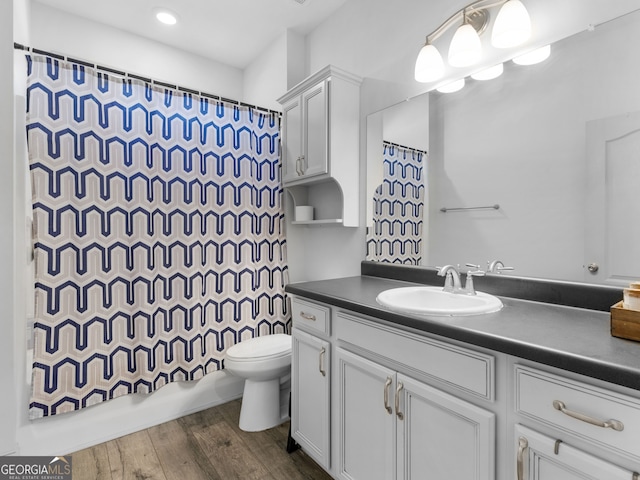 full bathroom featuring shower / bath combo, vanity, toilet, and wood finished floors