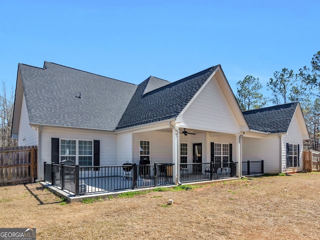 rear view of house featuring a patio area, a ceiling fan, and roof with shingles