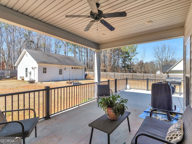 view of patio with a fenced backyard, a ceiling fan, and an outdoor structure