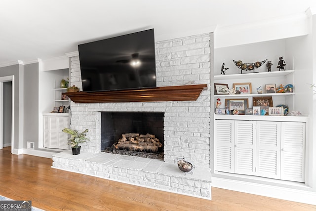 details with a fireplace, crown molding, visible vents, wood finished floors, and baseboards