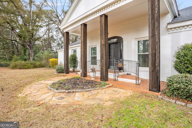 doorway to property with a yard and brick siding