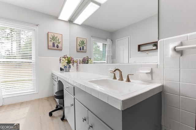 bathroom with wainscoting, wood finished floors, tile walls, and vanity